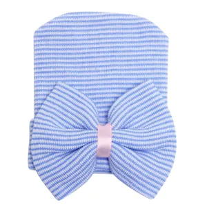 Vista detallada de un tierno gorro de bebé a rayas azul y blanco con un gran lazo decorativo.