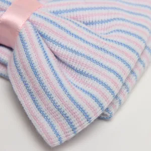 Detalle del gorro de punto para recién nacido, gorro de rayas rosa y azul con lazo.