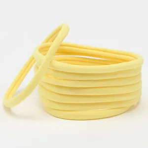 Detailed close-up view of soft yellow nylon baby headbands, showing seamless elastic texture.