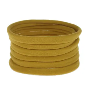 Detailed view of 10pcs mustard yellow elastic nylon headbands, soft baby hair accessories.