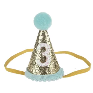 Cappello festa di compleanno per bambini con numero 3, glitter dorato e pompon blu decorativi.