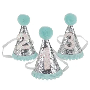 Dettagli dei cappelli di compleanno per bambini scintillanti con pon-pon e numeri.