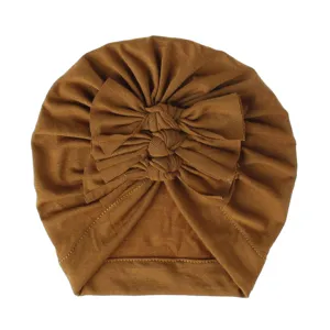 Soft knitted baby turban hat with multi-layered bow pleats, comfortable infant headwear detail.