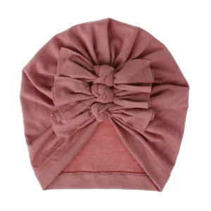 Detailed view of the cute baby turban hat with stylish triple bows and soft pleated knit fabric.