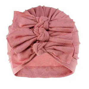 Detailed view of soft knit baby turban hat featuring a triple knotted bow design in dusty pink.