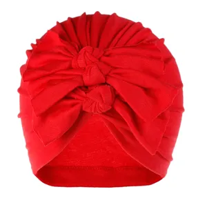 Red baby turban hat with big bow knot, soft knit pleated infant cap for daily wear detail.