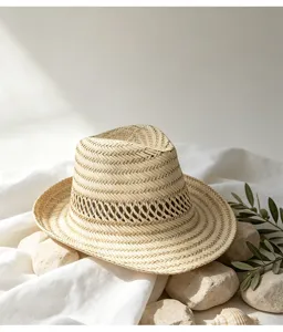 Vue détaillée d'un chapeau de paille d'été tressé sur des pierres avec des feuilles.