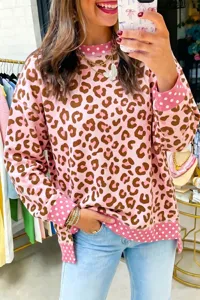 Detailed view of women pink leopard print sweatshirt featuring contrast polka dot cuffs and hem.