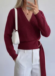 Close-up detail of the burgundy wrap knit sweater featuring a stylish side metal ring and belt.
