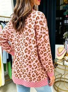Detail view of the pink leopard print sweatshirt, featuring contrasting polka dot cuffs and hem.