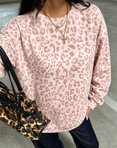 Détail en gros plan du sweat-shirt rose à imprimé léopard pour femme, col rond décontracté.