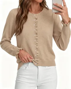 Detailweergave van de beige gebreide damesvest met volants en een comfortabele ronde hals.