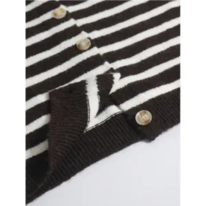 Detail view of women's brown and white striped knit cardigan sweater, soft texture.