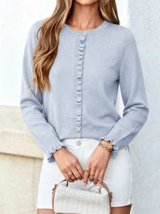 Lichtblauwe gebreide vest detail, ronde hals, lange mouwen met ruffles en knopen.