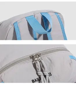 Rucksack Detailansicht zeigt robustes graues Gewebe, blaue Riemen und Metall-Reißverschlüsse.