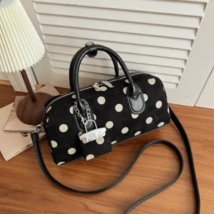 Detailed view of the black and white polka dot shoulder bag with stylish leather handles.