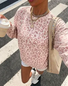 Vue de détail d'un sweat rose à imprimé léopard pour femme avec un sac porté épaule.