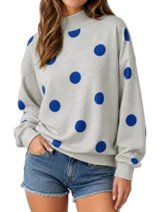 Primer plano de los detalles de la sudadera gris de cuello alto con lunares azules.