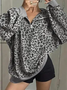 Dettaglio in primo piano felpa donna stampa leopardata mezza zip, stile casual chic.