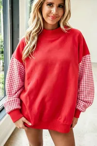 Vista detallada de la elegante sudadera roja extragrande con mangas de cuadros de moda.