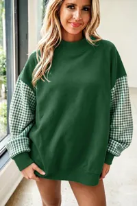 Primer plano detallado de la sudadera verde informal con cuello alto y mangas a cuadros.