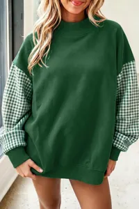 Cómoda sudadera verde holgada con cuello alto y mangas de cuadros de suave tejido.