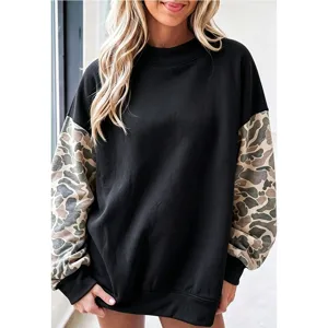 Dames oversized fleece sweatshirt met camouflage contrastmouwen en opstaande kraag.