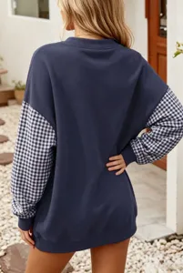 Vue détaillée du sweat-shirt ample avec des manches patchwork à carreaux élégantes.