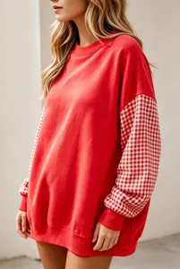 Sweat-shirt rouge à col rond avec des manches à carreaux et une coupe ample et confortable.