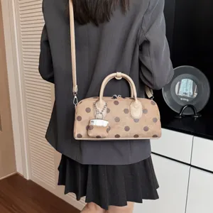 Detail view of the trendy Korean style polka dot shoulder bag with handle and strap.