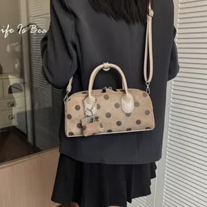 Korean style polka dot shoulder bag detail, elegant brown suede material with chic lock charm.
