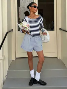Gedetailleerd overzicht van blauw-wit gestreepte gebreide top met lange mouwen en shorts.