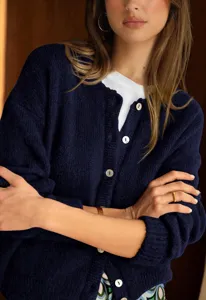 Detail of women's dark blue knitted cardigan with buttons and round neckline, cozy style.