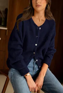 Detailed view of the women's navy blue knit cardigan with round neck and white button closure.