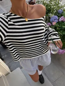 Close-up detail van casual zwart-wit gestreepte gebreide top met blote schouders.