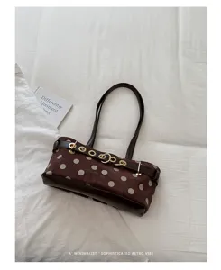 Borsa a tracolla marrone a pois, dettaglio di borsa baguette vintage per donna autunno.