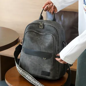 Primo piano dello zaino grigio, tracolla larga e tasche con zip per viaggi quotidiani.