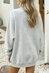 Confortable sweat-shirt oversize gris femme avec manches longues à carreaux et col rond stylé.