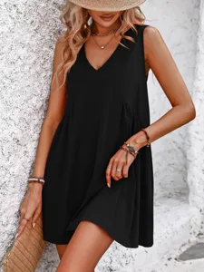 Close-up of black sleeveless V-neck summer dress worn by model against textured white wall.