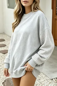 Vue détaillée du sweat-shirt gris oversize pour femme avec manches à carreaux contrastés.