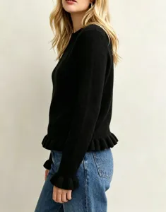 Close-up of black knit sweater with ruffle hem and long sleeves, chic daily fashion piece.