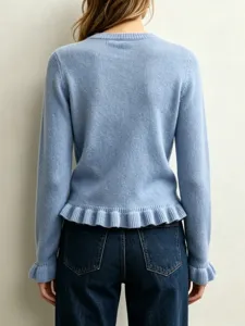 Detailed view of back of light blue knit sweater featuring stylish ruffle hem and cuffs.