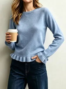Close-up detail of light blue knit sweater featuring a stylish crewneck and ruffled hem.