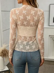 Detailed back view of women sheer mesh floral lace long sleeve top paired with blue jeans.