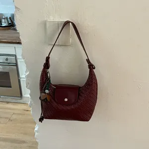 Burgundy woven leather underarm bag, elegant dumpling shoulder bag for women commuting daily.