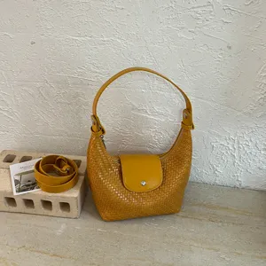 Yellow woven dumpling shoulder bag with top handle and strap for women commuter daily use.