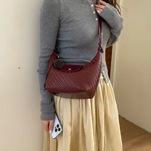 Woven dumpling shoulder bag for women, stylish crossbody commute handbag with top flap design.