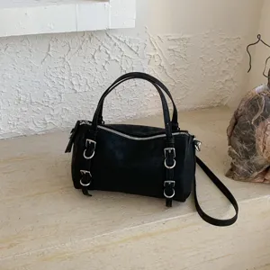 Vista dettagliata della borsa a mano nera da donna con fibbia in metallo e chiusura lampo.