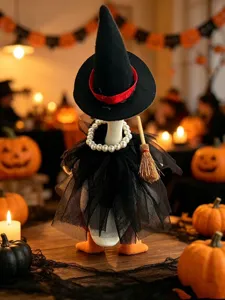 Nahaufnahme einer süßen Halloween Entenfigur im Hexenkostüm mit Perlenkette und kleinen Besen.