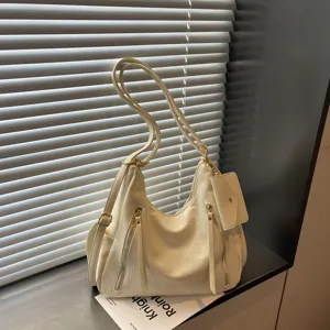 Detailed view of cream white shoulder tote bag with double straps and front zipper pockets.